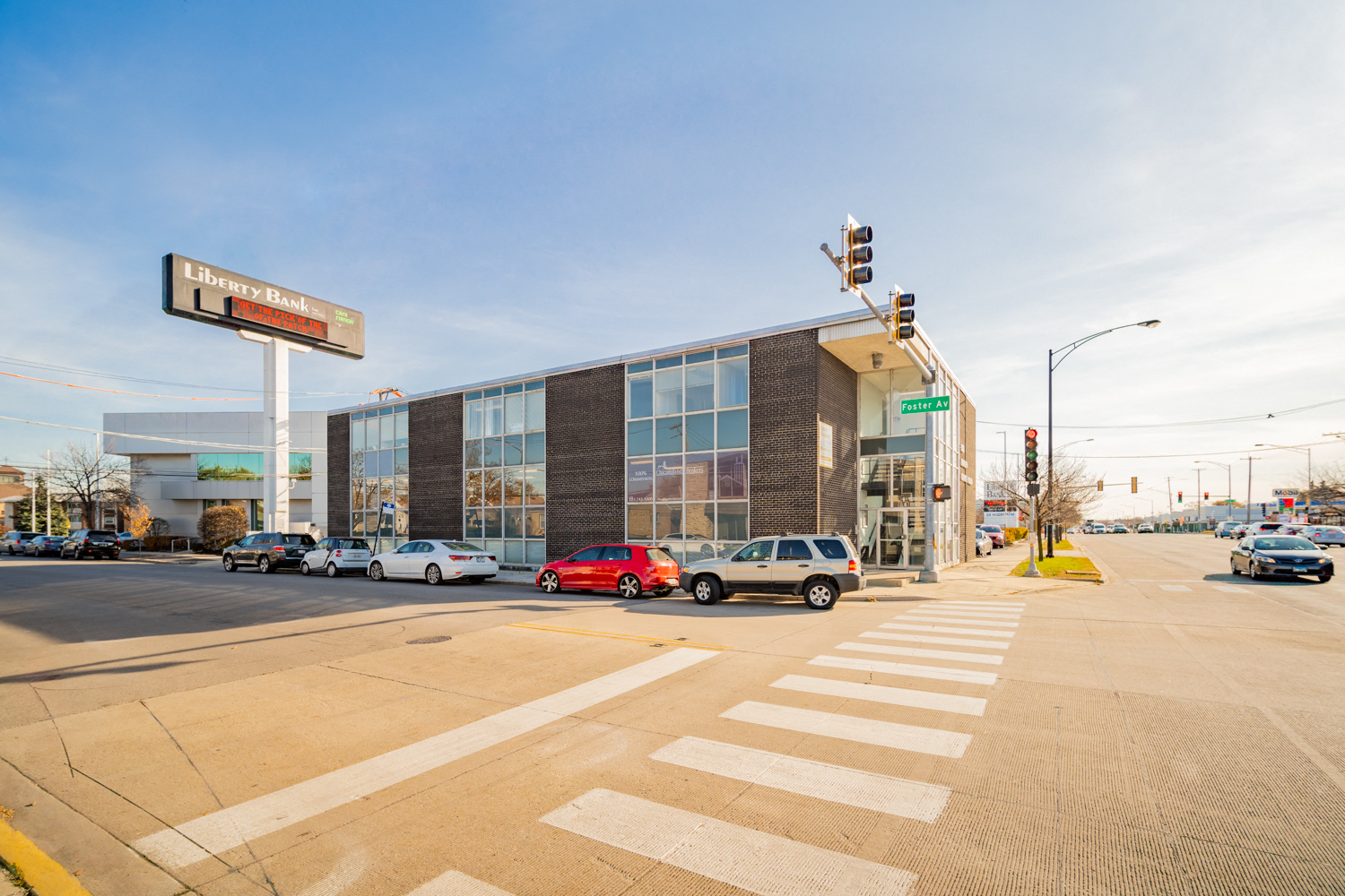 a large building with cars parked in front of it at an intersection